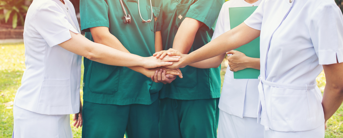 hands together between the doctor and nurses